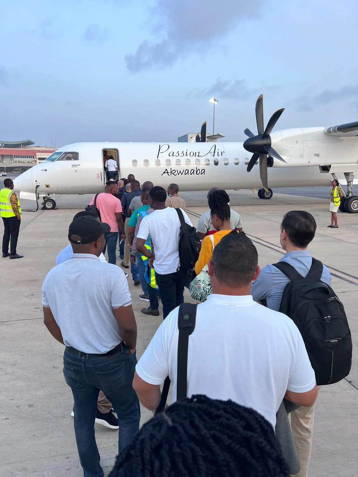 Passengers walking to a turboprop aircraft on an airport apron